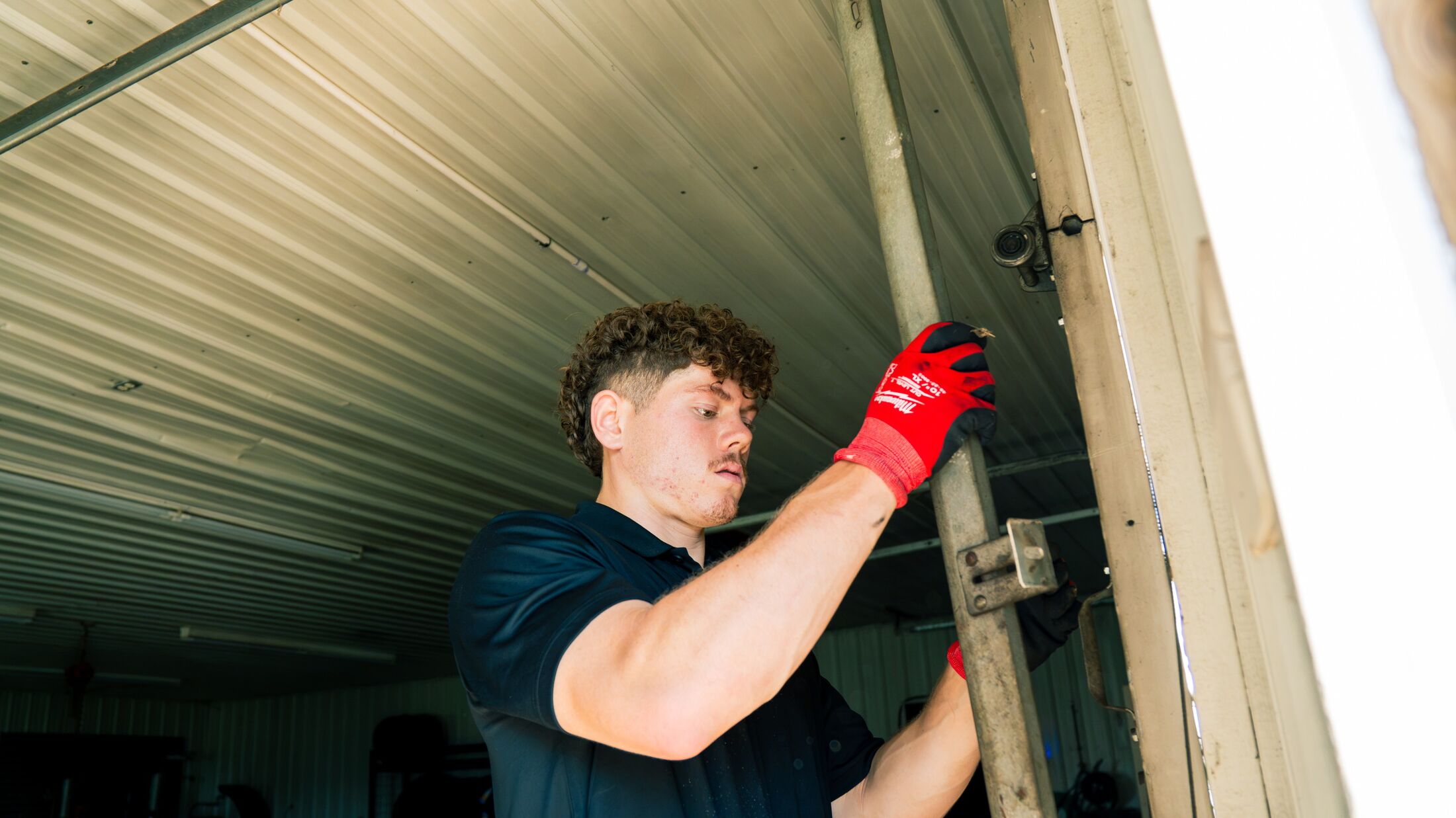 An Elevation technician at an open garage door on a warm day in the Grand Rapids metro