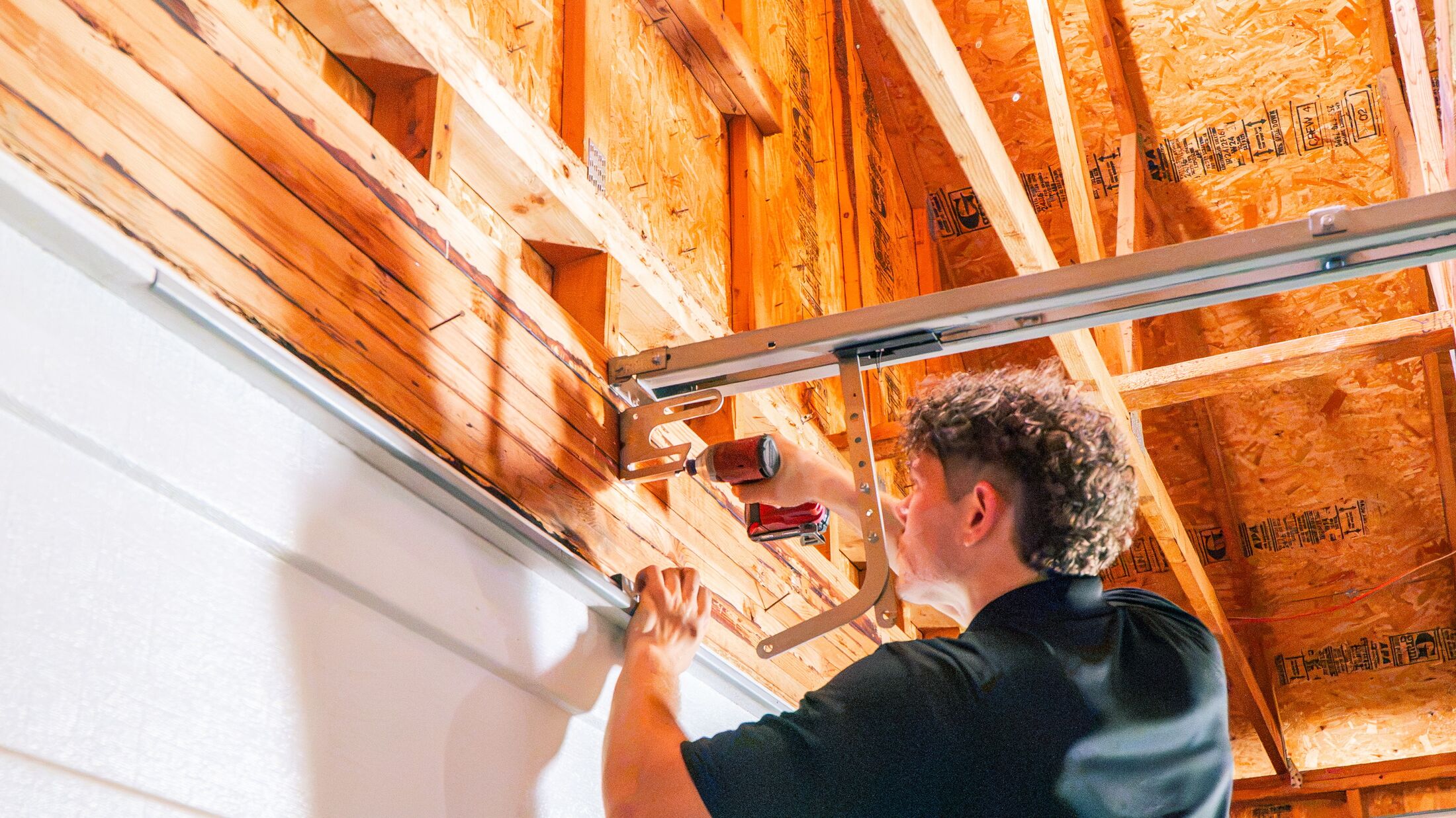 An Elevation technician working along the horizontal track of a garage door